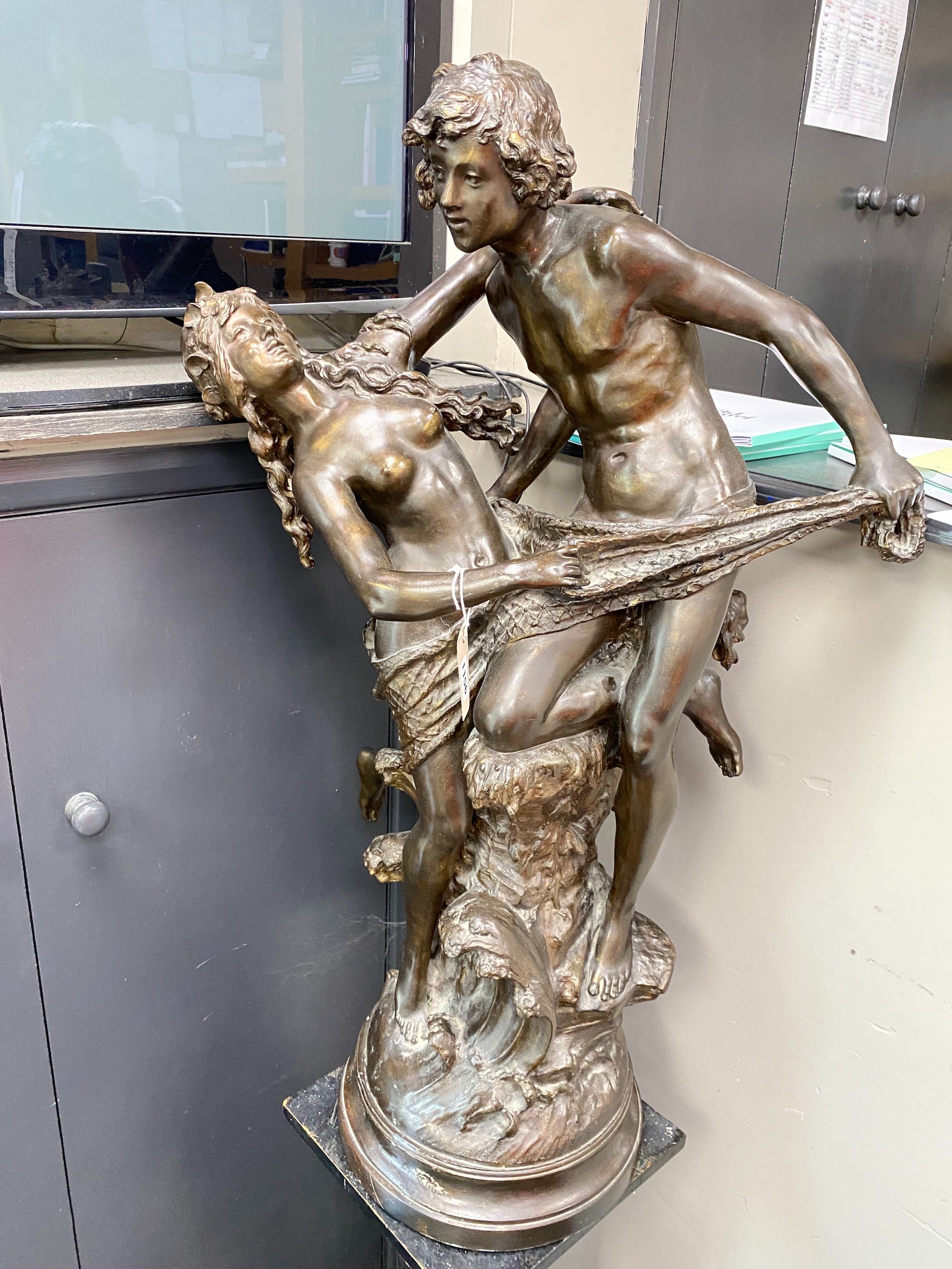 A bronzed metal group of a dancing couple on associated wood plinth combined height 170cm